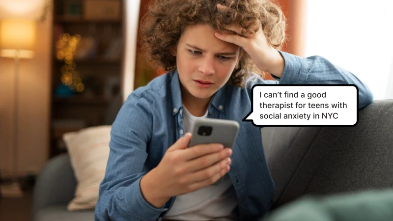 Therapy Website Mistakes That Are Costing You New Clients Man is worried, sitting on couch holding a phone, can't find a good therapist for teens with social anxiety in New York City